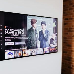 Smart TV displaying streaming content in modern living room setting with exposed brick wall.
